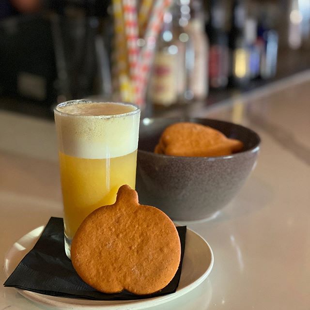 Cookie on a plate leaning on a glass of liquid