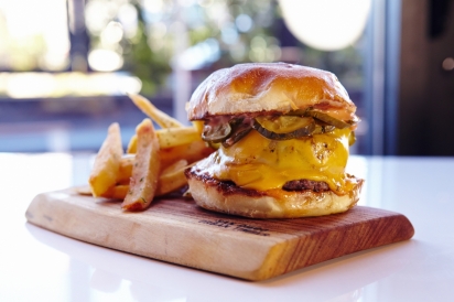 Secret burger on a plank of wood with fries