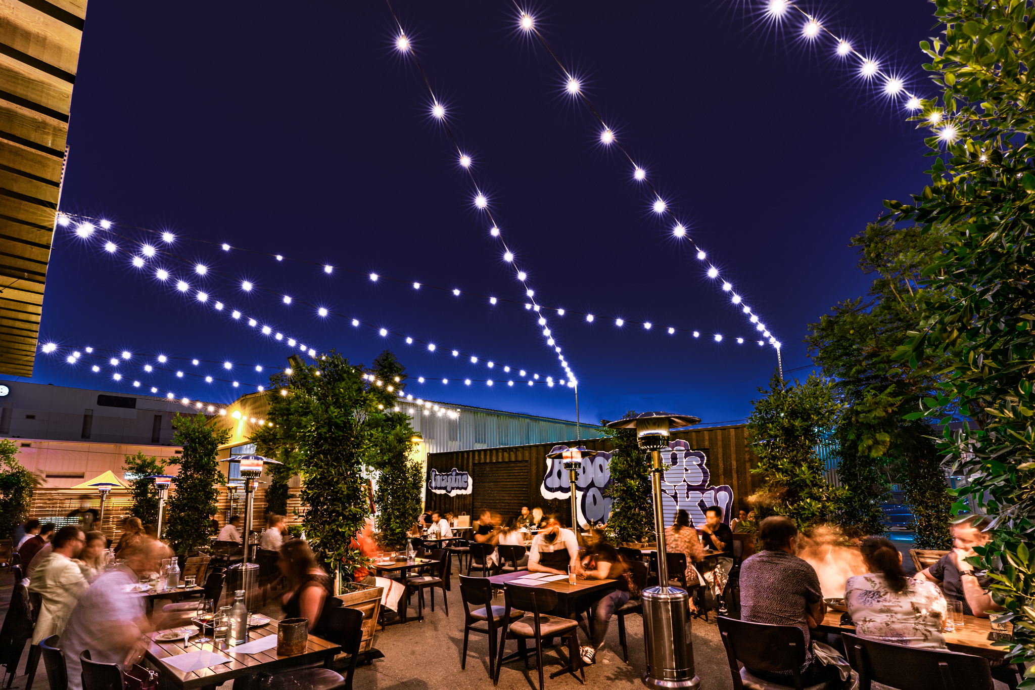 outdoor patio at juniper and ivy with happy diners under the stars and patio lights
