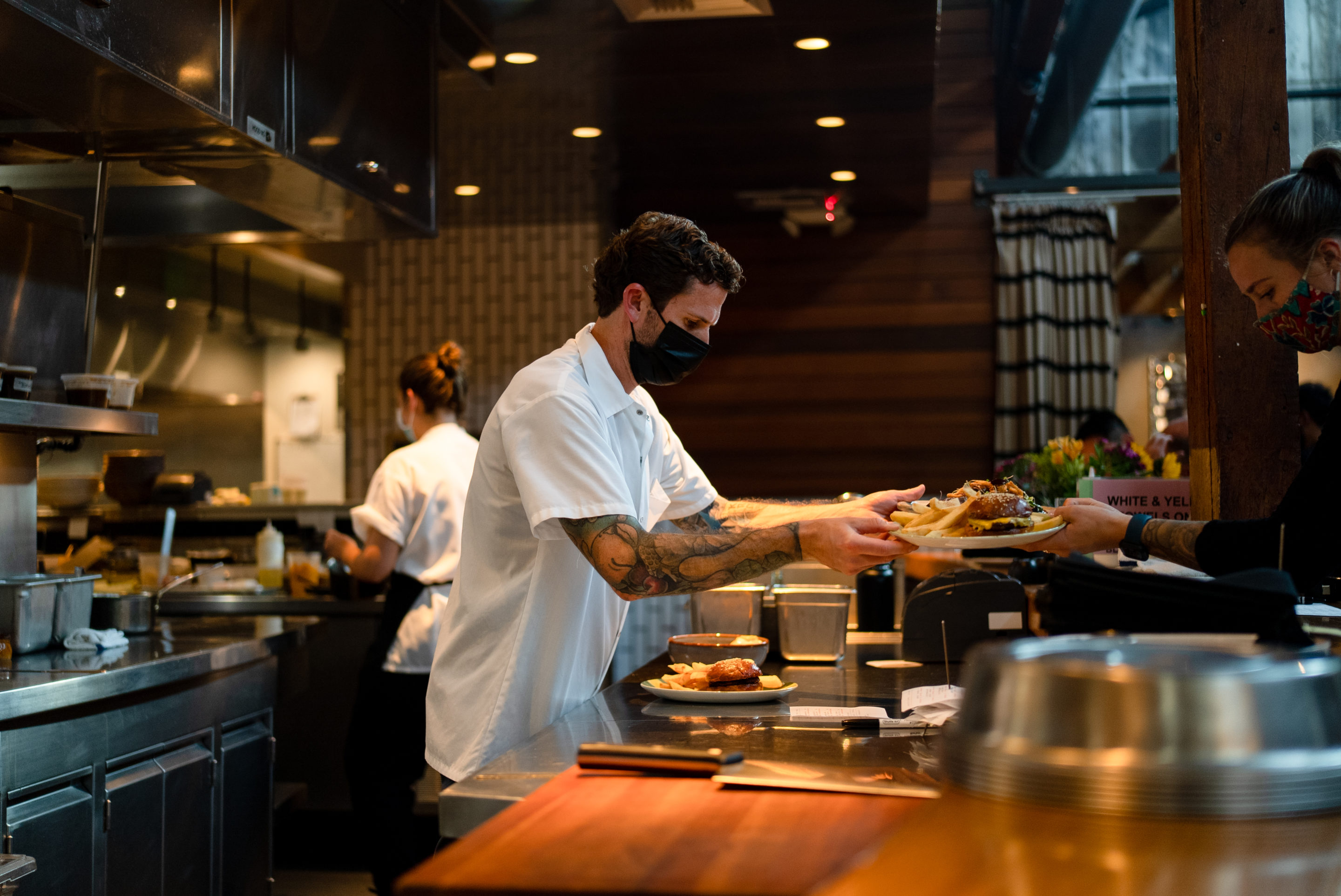 Chef handing a plate to a server