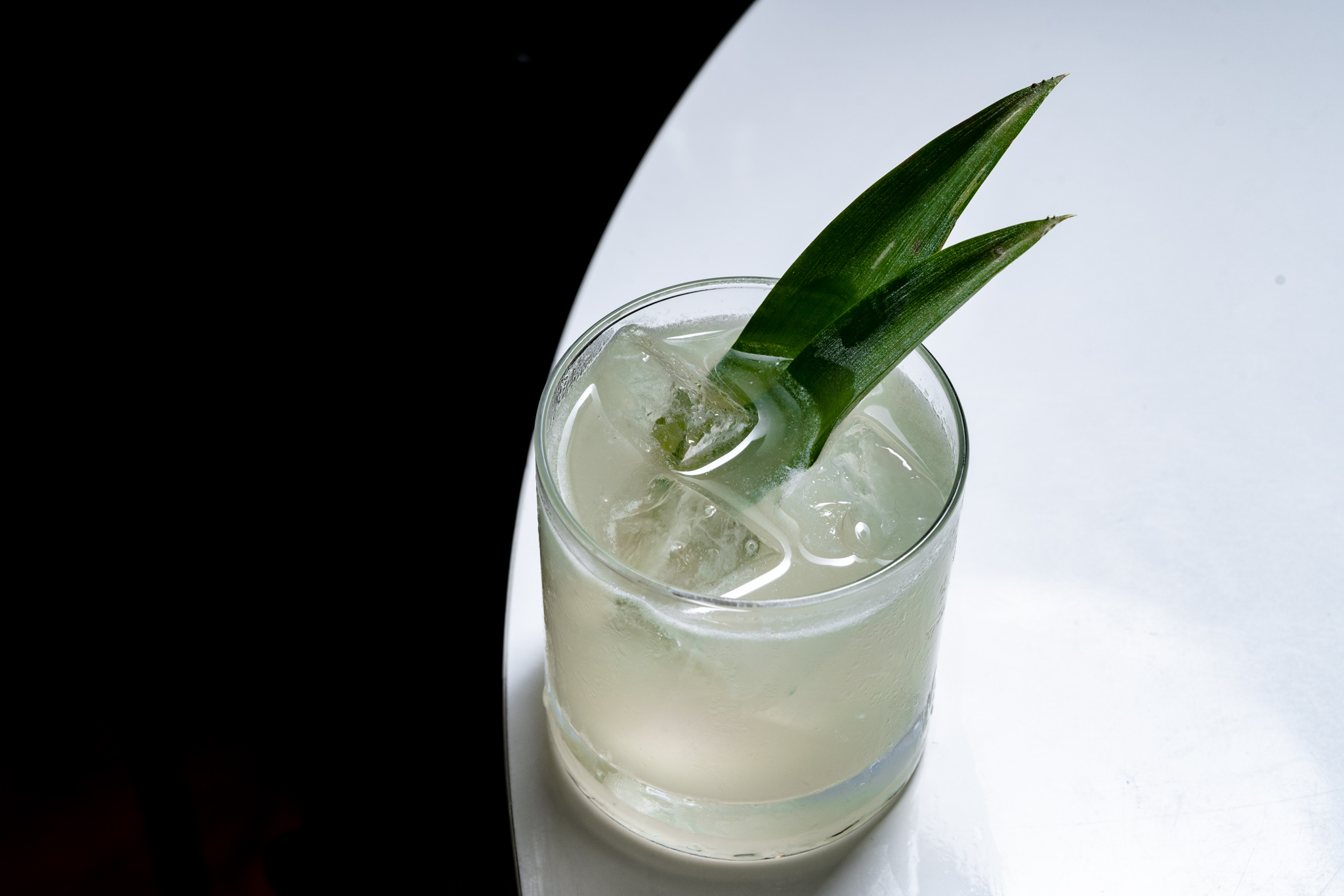 Light cocktail on a table with aloe sticking out