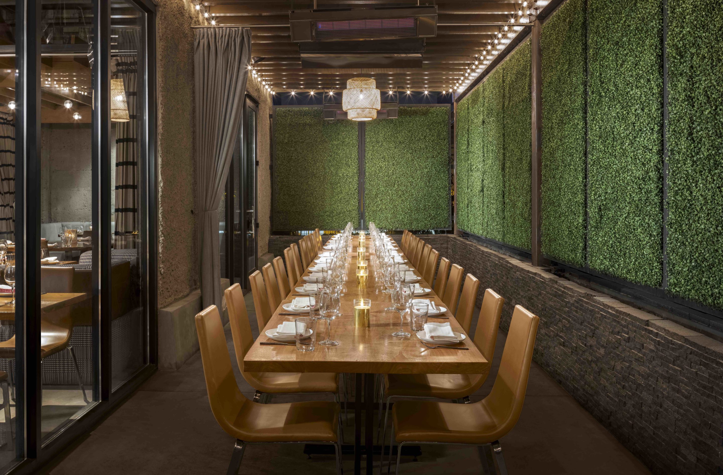 Outdoor shot of long table surrounded by fake grass wall