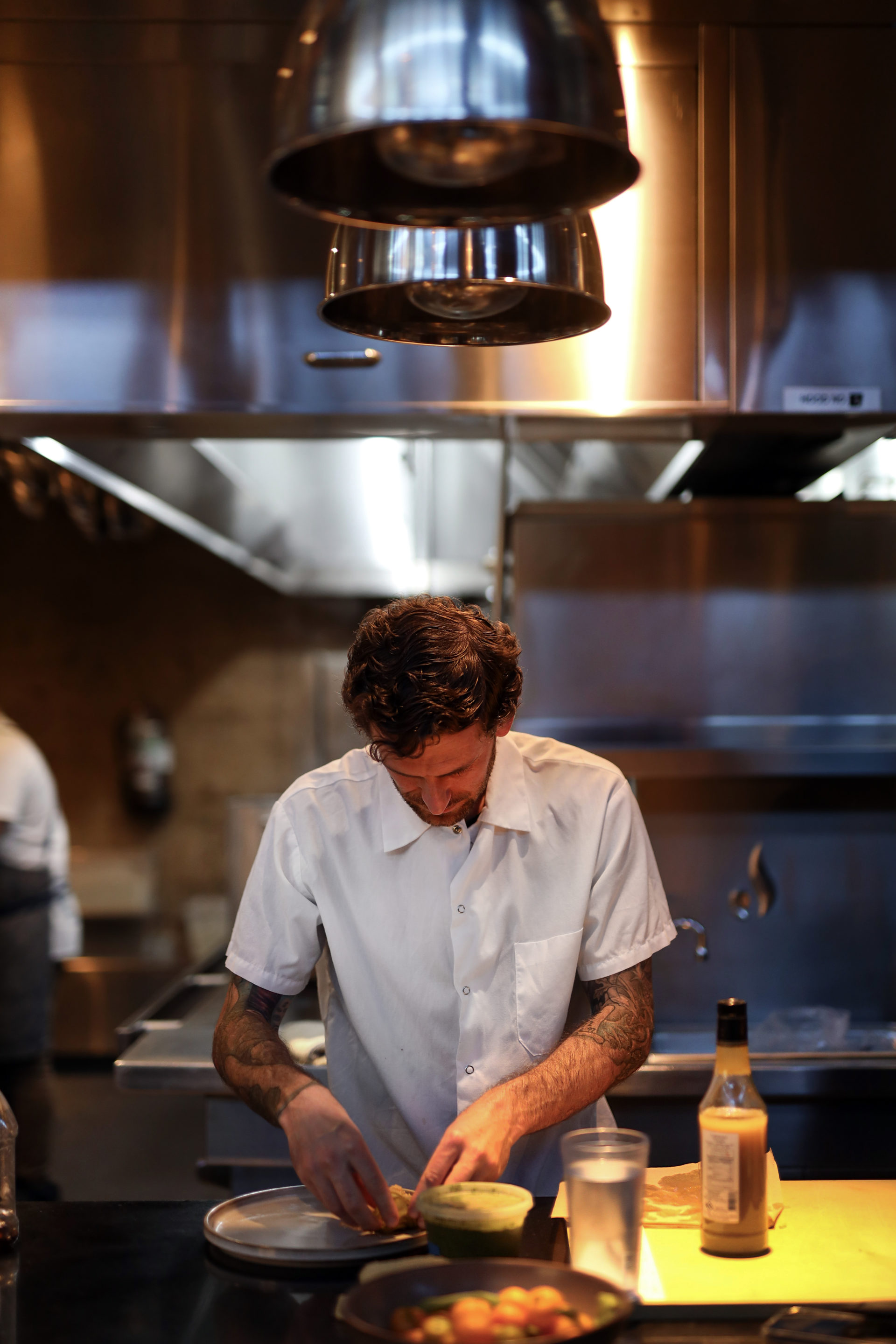 man plating dish in kitchen