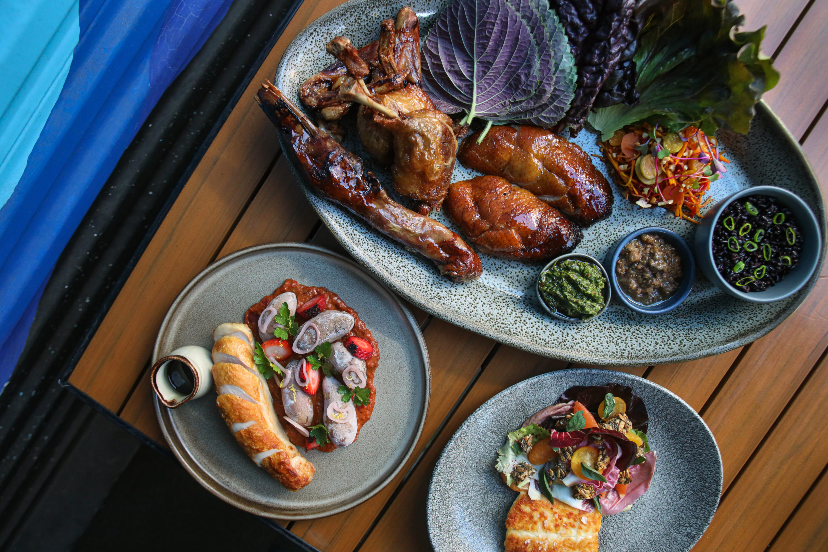 Overhead image of duck for two, chicken plate, and local catch