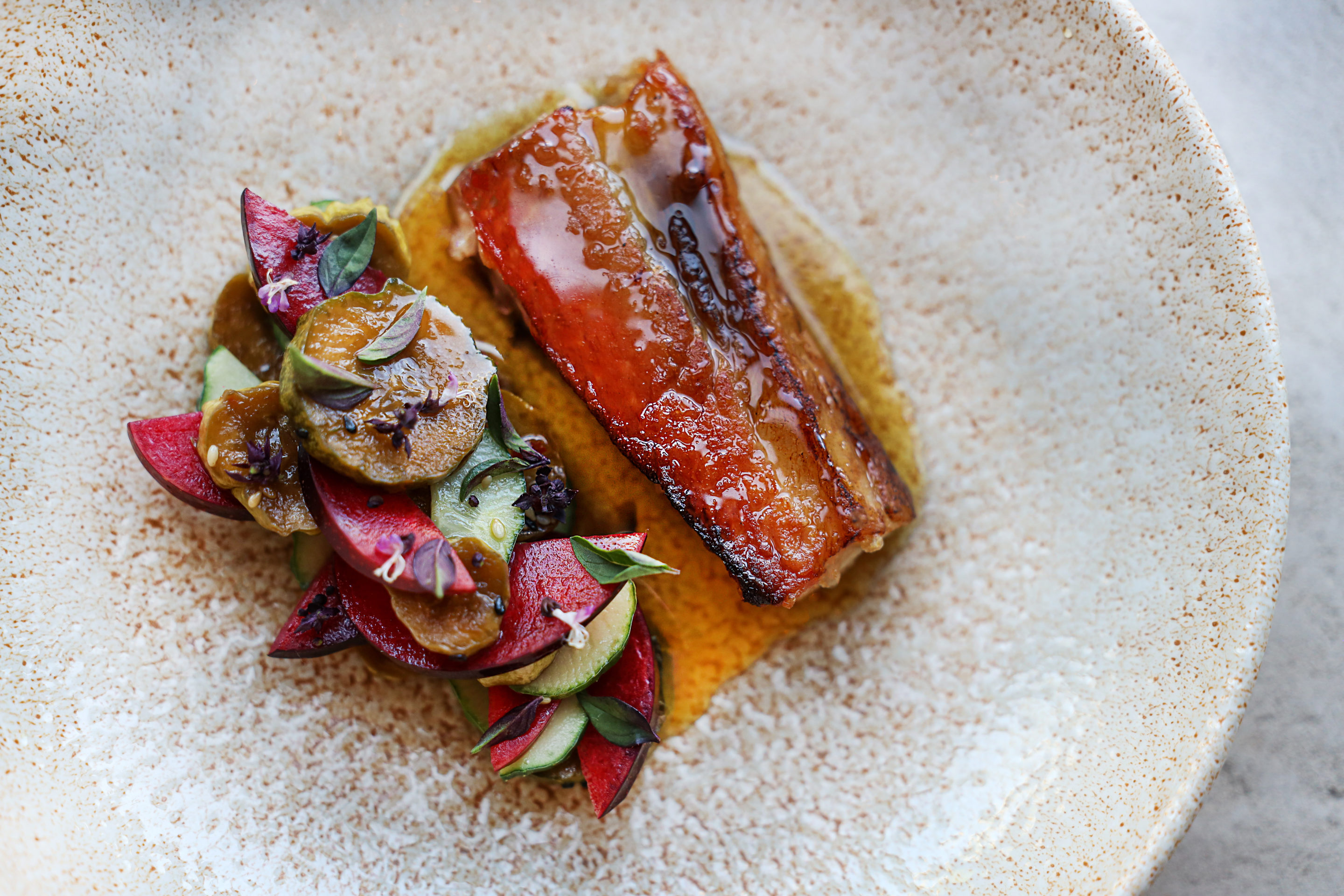 Close up of pork belly and vegetables on a plate