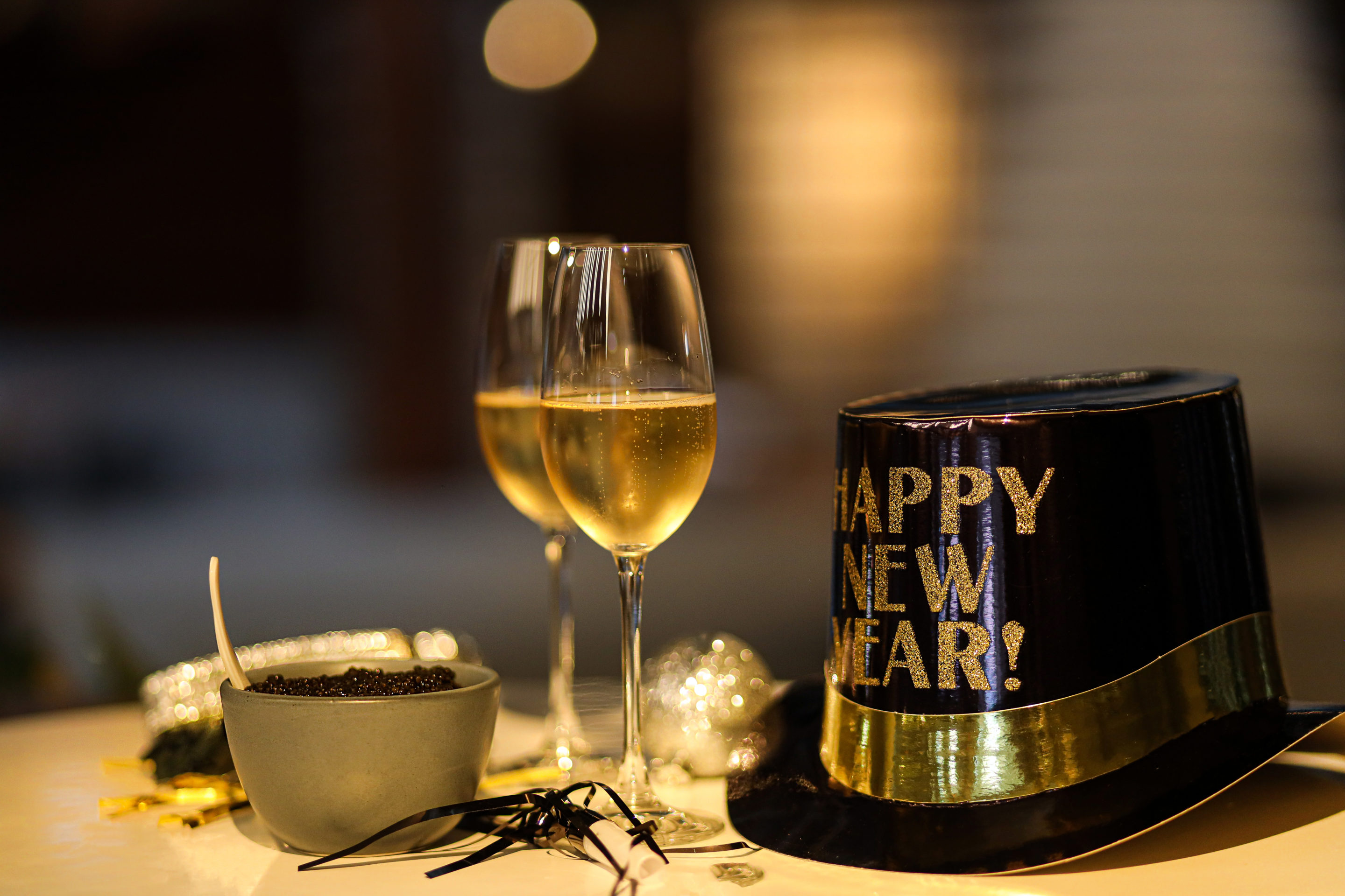 Champagne glasses next to NYE hat