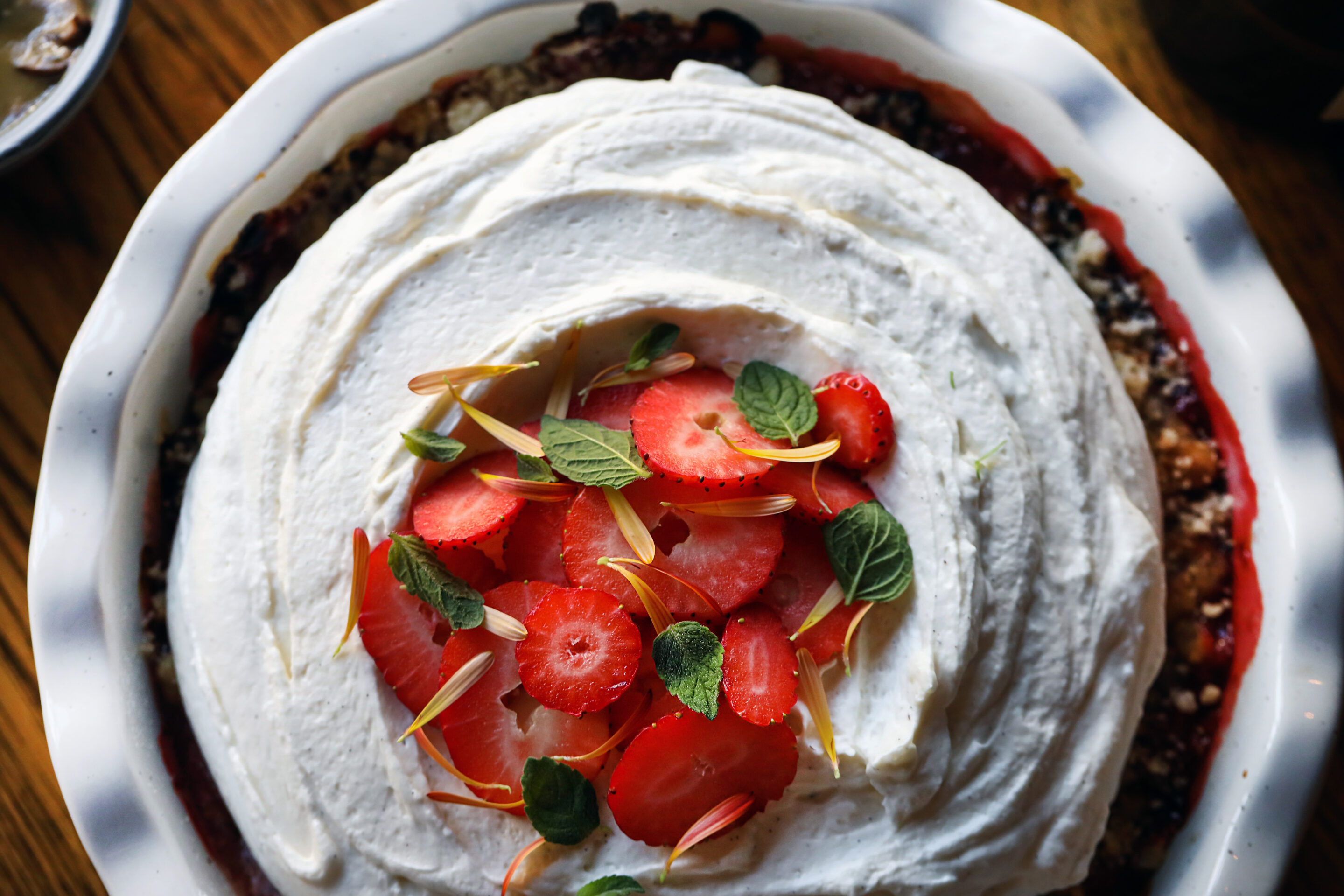 Overhead shot of cake with icing and strawberries on top.