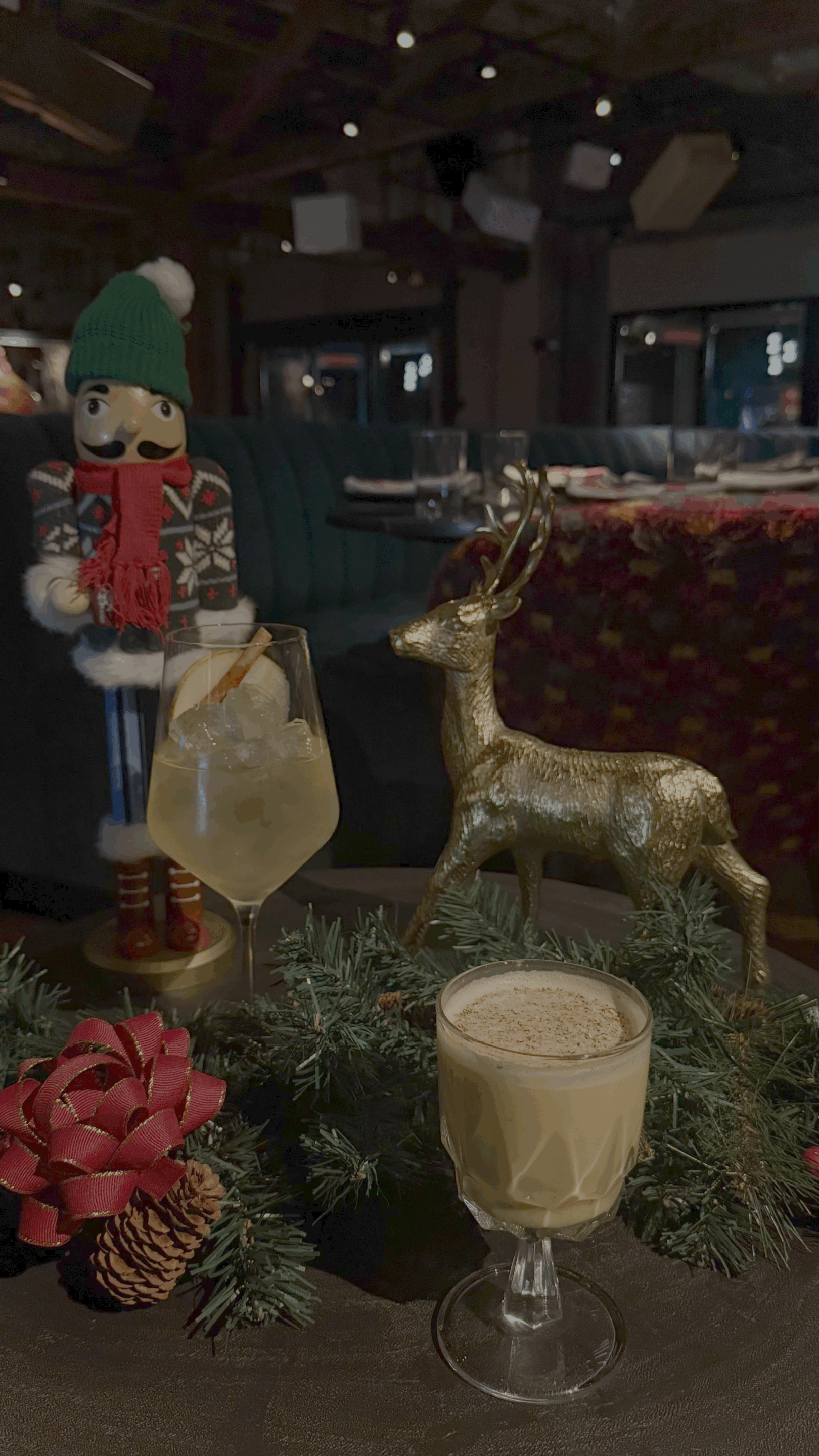 Two cocktails surrounded by festive holiday props and decor.